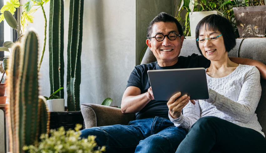 A man and woman sitting on couch looking at screen